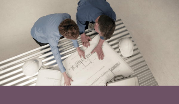 Two professionals looking over building plans